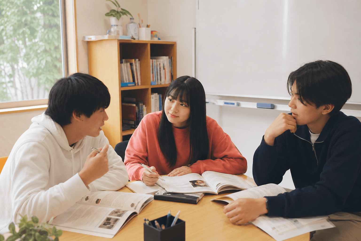 英語で話し合う中学生と高校生